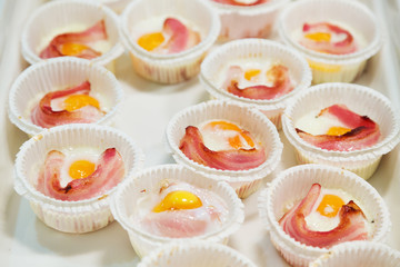 Portions of scrambled eggs and bacon for breakfast