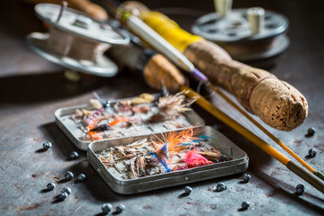 Articles de pêche avec mouches et cannes à pêche sur table en métal
