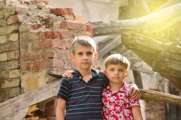 Poor and neschatnye children on the ruins of a burnt house. The brothers suffered a natural disaster.