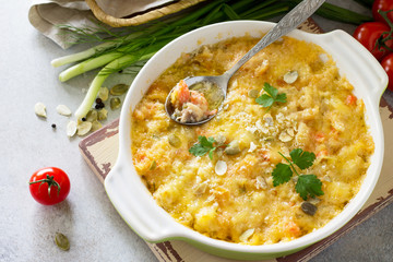 Casserole crumble with red fish, white bread and cheese on stone or slate background. Proper nutrition. Healthy lifestyle.