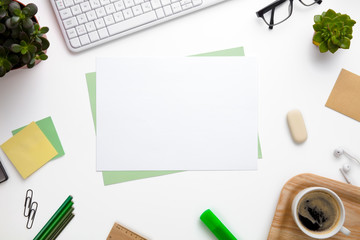 Blank Papers Surrounded With Office Supplies On White Desk