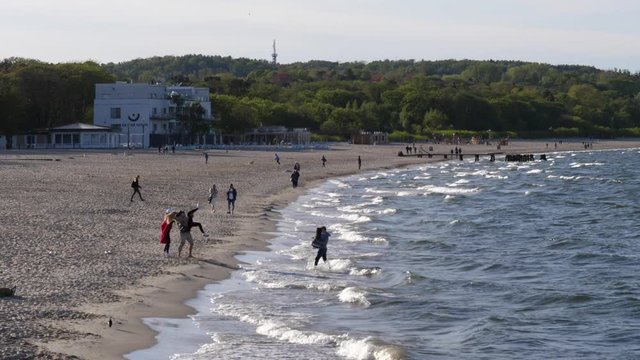 Baltic Sea sand beach coastline in evenint with people walking in Sopot Poland