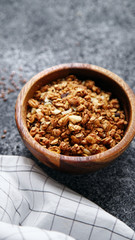 Granola in wooden bowl on gray background. Flatlay with copy space