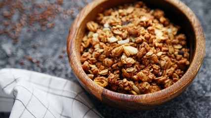 Granola in wooden bowl on gray background. Flatlay with copy space