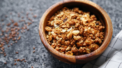 Granola in wooden bowl on gray background. Flatlay with copy space