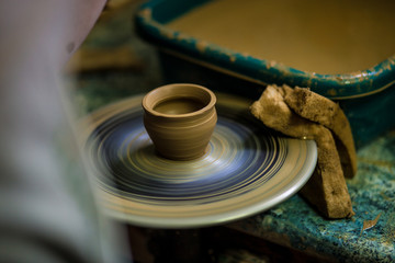 Creating jar or vase of clay close-up. Master crock. Man hands making clay jug macro. sculptor in workshop jug out of earthenware closeup. Twisted potter's wheel