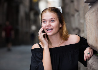young positive female talking on phone
