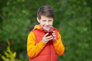 Smiling Caucasian boy with a glass of juice.