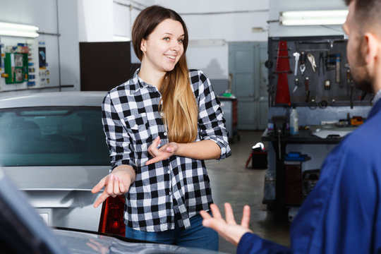 Young woman is satisfied of tire replacement of her car in spring