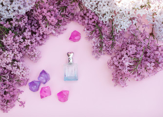 Glass jar and lilac flowers on the background for spa and aromatherapy, copy space for text.