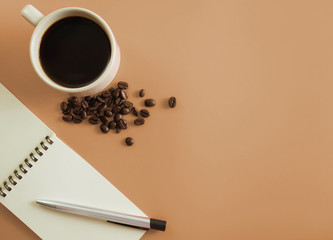 Flat lay brown desk with notebook and a cup of coffee  with copy space