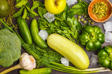 Green vegetables on a dark background. Vegetable vegan diet food background, top view. Healthy lifestyle concept.