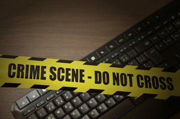 Computer keyboard with do not cross crime scene tape