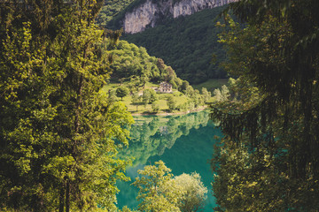 Fototapeta na wymiar Lago di tenno with mountain and trees reflection in water. Tenno, Privincia di Trento, Trentino0Alto Adige, Italy