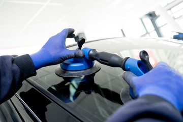 Automotive glazier equipment for replace windscreen. In auto service station garage.