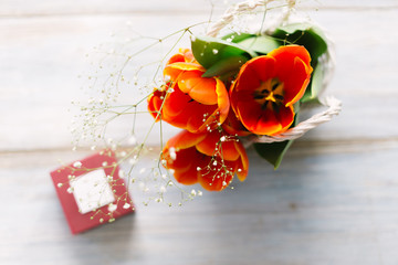 Tulips in a basket on a white wooden background