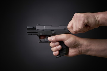 reloading a handgun, pulling back slide, side view