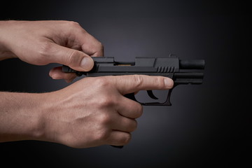 reloading a handgun, pulling back slide, side view