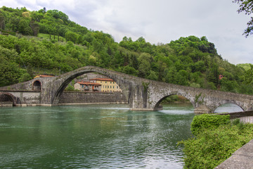 Fototapeta na wymiar Stone arch bridge from the 14th century over the river Serchio Ponte della Maddalena