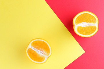 Fruits of oranges on a multicolored background, halves of oranges on colored paper. Copy space. Citrus in the style of pop art