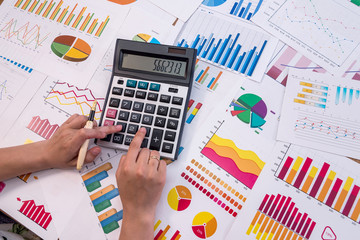 Hands of business analyst calculating graphs and diagrams