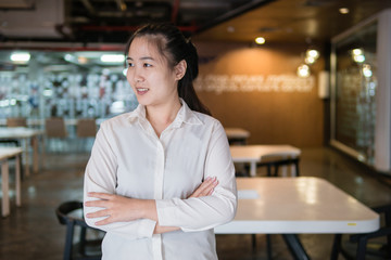 Head And Shoulders Portrait Of Young Businesswoman with white shirt In Office and table background.Copy space