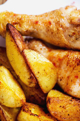 a tasty dish for the holiday, a new year or Christmas, baked potatoes with chicken legs, spices, paprika, sesame, bagel, olive oil, red wine on a wooden background