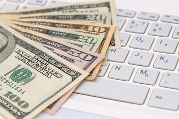 dollar bilsl on white keyboard laptop. close up