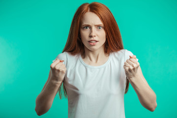 Destressed, angry, irritated young pretty woman or jealous wife isolated over blue background....