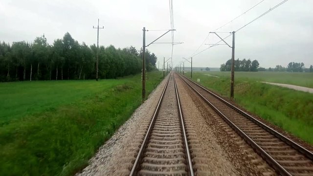 View of the Train Track from the Rear Window from the Moving Train A, Passing through rural area in Poland