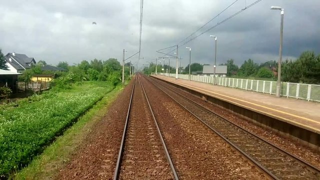 View of the Train Track from the Rear Window from the Moving Train B, Passing through rural area in Poland