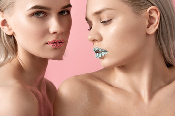 Close up of gorgeous young women with creative spring makeup. Isolated on pink background