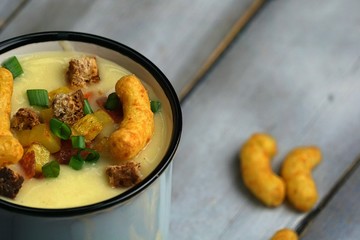 potato soup. vegetable soup. iron mug. rustic style. on a wooden table.