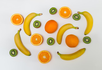 Food pattern made of oranges, kiwi fruits and bananas on pastel background