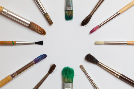 A circle of paint brushes on the white background
