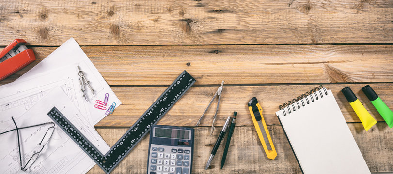 Architect workplace. Project construction blueprints and engineering tools on wooden desk, copy space