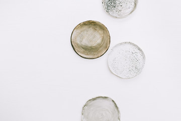 Handmade plates on white background. Flat lay, top view artist minimal concept.