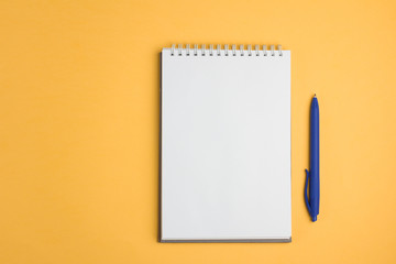 Blank notebook with pen on yellow pastel background. Flat lay concept. Copy space