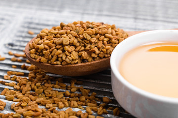 fragrant grains of fenugreek on a rustic background