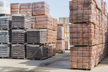 pallets with bricks in the building store. Racks with brick. Masonry, stonework. Several pallets with concrete brick stacked on top of each other in depot. new bricks on pallets.