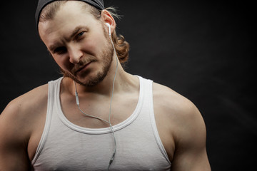 Caucasian fair-haired bodybuilder in black cap looking at the camera with suspicious look