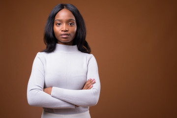 Fototapeta premium Young beautiful African Zulu businesswoman against brown backgro
