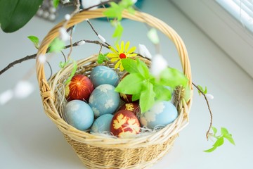 Naturally painted Ester Eggs in basket with hay and leaves