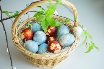 Naturally painted Ester Eggs in basket with hay and leaves