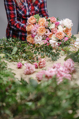 Obraz na płótnie Canvas Female florist. Floral workshop - woman making a beautiful flower composition a bouquet. Floristry concept