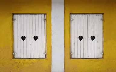 divided yellow wall with white shutters