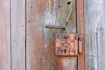 an image of an old door handle in a wooden door