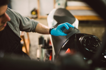 Mechanic polishing and cleaning a motorcycle