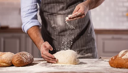 Photo sur Aluminium Boulangerie les mains du mâle du boulanger pétrissent la pâte.