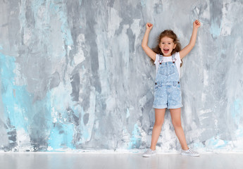 happy funny child girl   near   empty wall